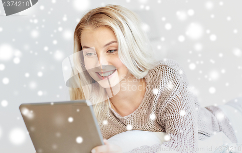 Image of happy young woman with tablet pc in bed