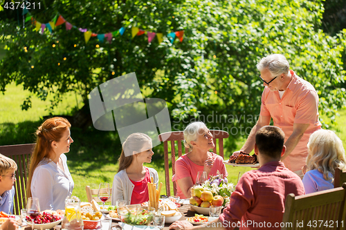 Image of happy family having dinner or summer garden party