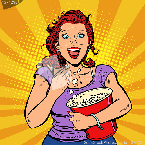 Image of Woman watching a movie, smiling and eating popcorn