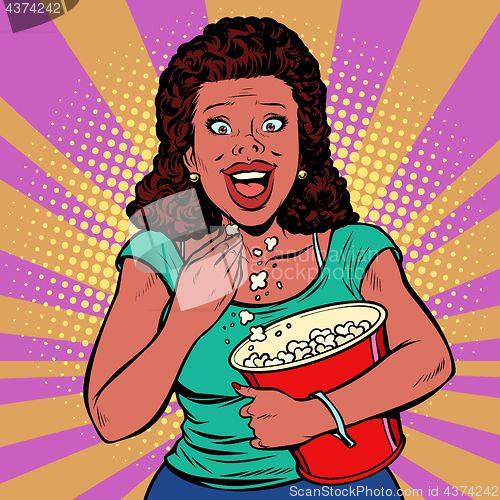 Image of Woman watching a movie, smiling and eating popcorn
