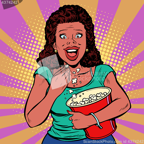 Image of Woman watching a movie, smiling and eating popcorn