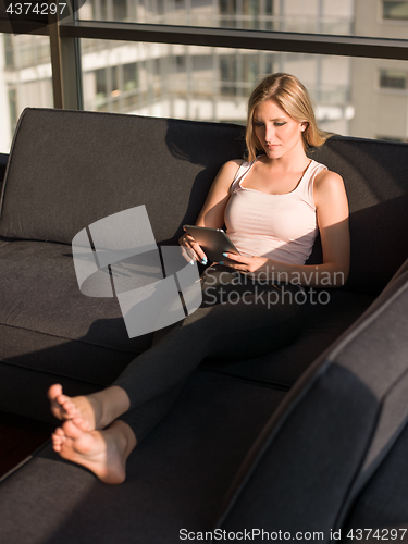 Image of Woman Using Tablet On Couch At Home