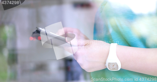 Image of Woman using tablet at home by the window