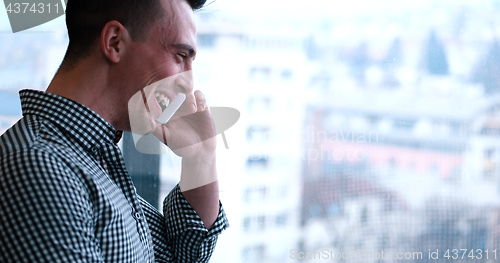 Image of Business Man Talking On Cell Phone, Looking Out Office Window