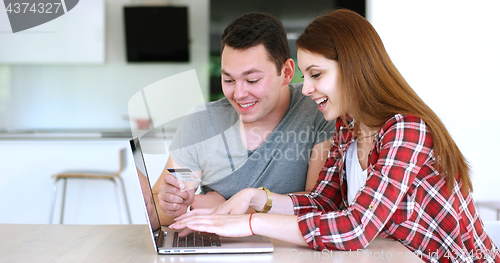 Image of Couple Using Laptop To Shop Online in modern apartment