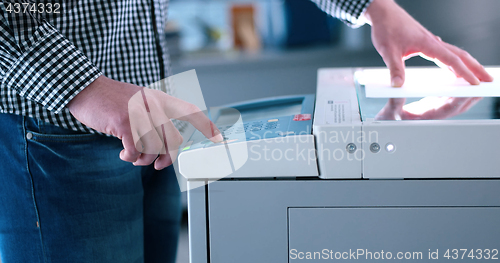 Image of Male Assistant Using Copy Machine in modern office