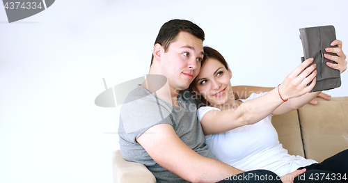 Image of Young Couple using digital tablet at home