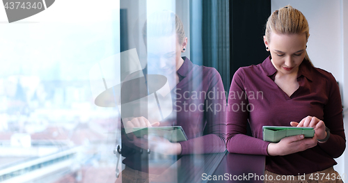 Image of Pretty Businesswoman Using Tablet In Office Building by window