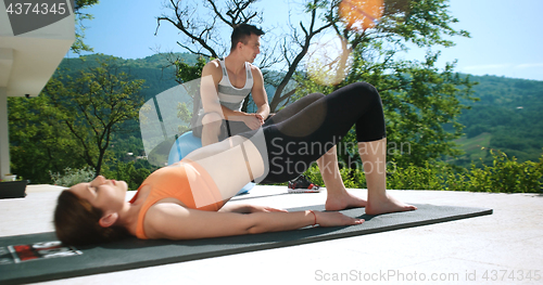 Image of Couple Doing Stretching Exercises Together in front of luxury vi