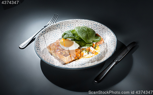 Image of Scrambled eggs on meat with fried potatoes and toast