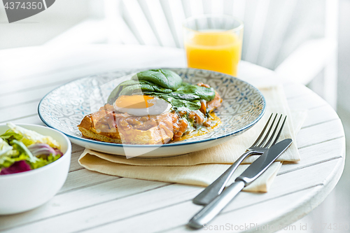 Image of Scrambled eggs on meat with fried potatoes and toast