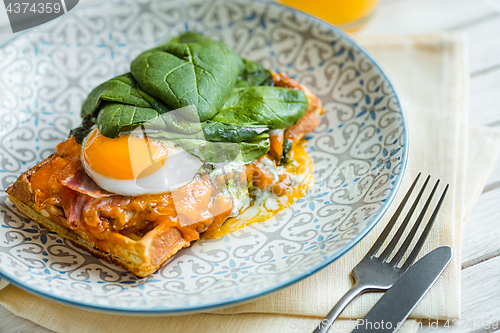 Image of Scrambled eggs on meat with fried potatoes and toast