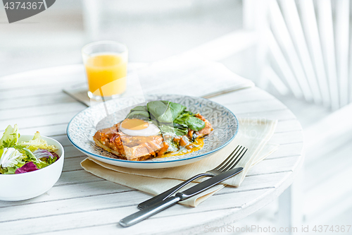 Image of Scrambled eggs on meat with fried potatoes and toast