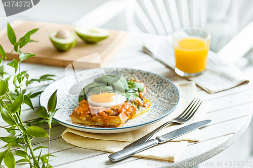 Image of Scrambled eggs on meat with fried potatoes and toast