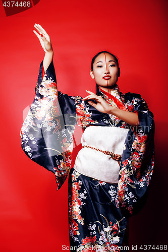 Image of young pretty geisha on red background posing in kimono, oriental people concept close up