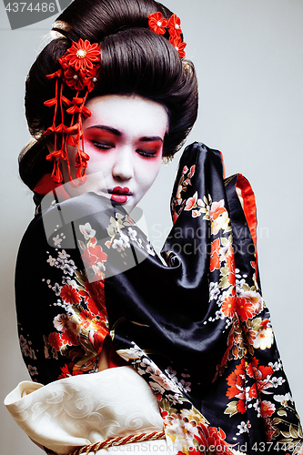 Image of young pretty geisha in kimono with sakura and red decoration design on white background