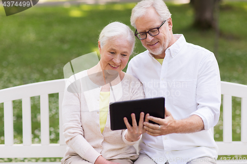 Image of happy senior couple with tablet pc at summer park