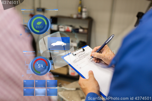 Image of auto mechanic with clipboard and man at car shop