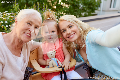 Image of happy family taking selfie at cafe