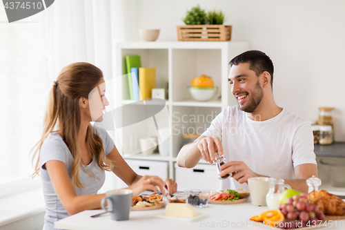 Image of happy couple having breakfast at home