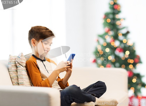 Image of boy playing on smartphone at home at christmas