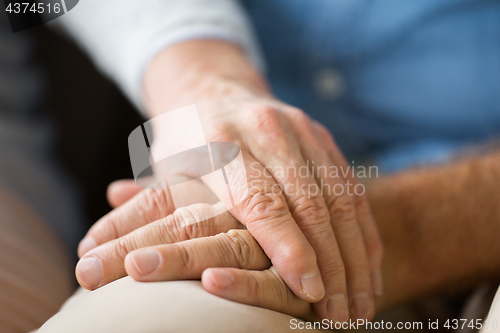 Image of close up of senior couple holding hands