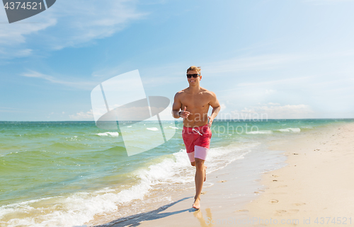 Image of happy man running along summer beach