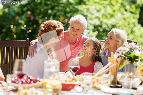 Image of happy family having dinner or summer garden party