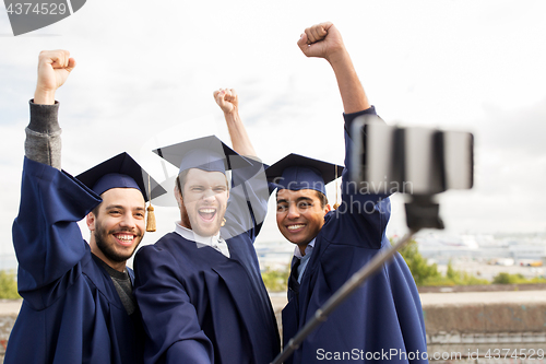 Image of happy male students or graduates taking selfie