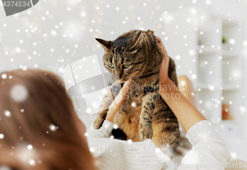 Image of young woman with cat lying in bed at home