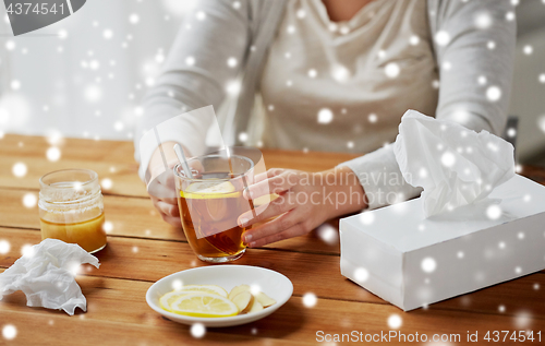 Image of close up of ill woman drinking tea with lemon