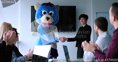 Image of boss dresed as bear having fun with business people in trendy of