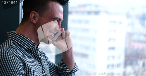 Image of Business Man Talking On Cell Phone, Looking Out Office Window