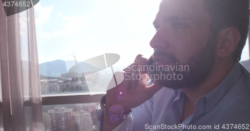 Image of Business Man Talking On Cell Phone At Home