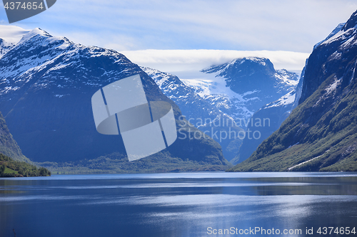 Image of A beautiful spring day with snow on the mountain peaks, blue sky