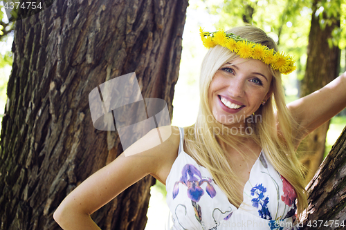 Image of happy blond young woman in park smiling, floral close up