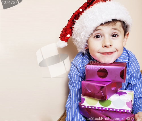 Image of little cute boy with Christmas gifts at home. close up emotional