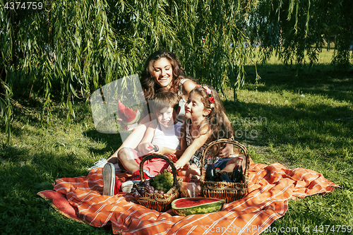Image of cute happy family on picnic laying on green grass mother and kid