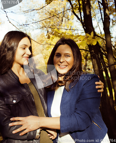 Image of mature real mother with daughter outside autumn fall in park