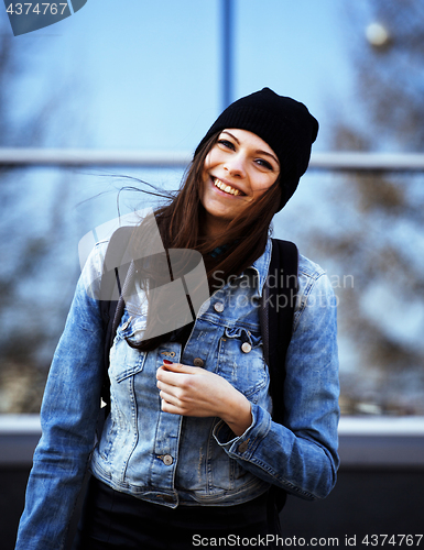 Image of young pretty girl near business building walking