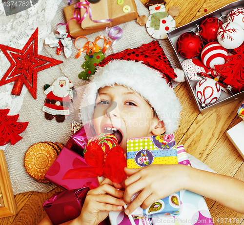 Image of little cute boy with Christmas gifts at home. close up emotional