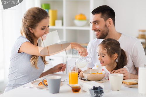 Image of happy family having breakfast at home