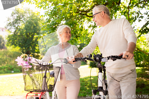 Image of happy senior couple with bicycles at summer park