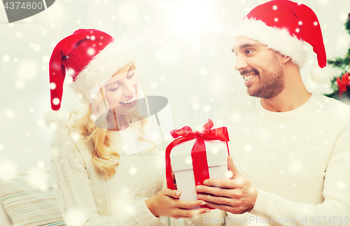 Image of happy couple at home with christmas gift box