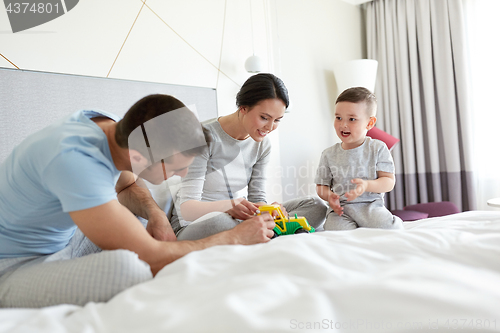 Image of happy family in bed at home or hotel room