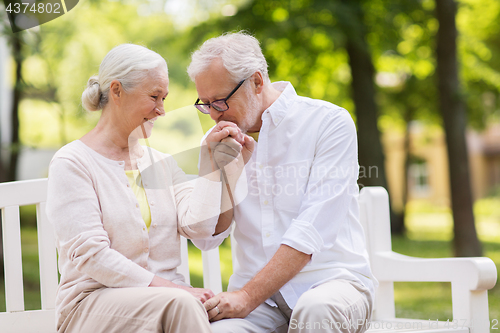 Image of happy senior couple sitting on bench at park