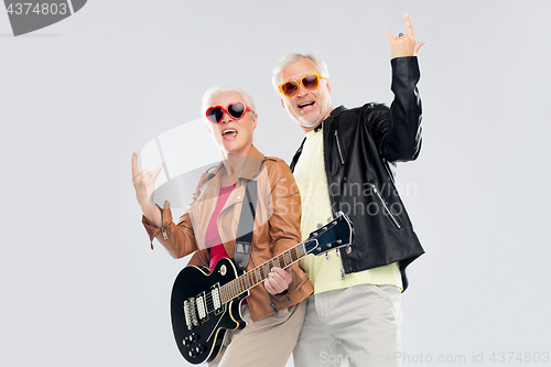 Image of senior couple with guitar showing rock hand sign