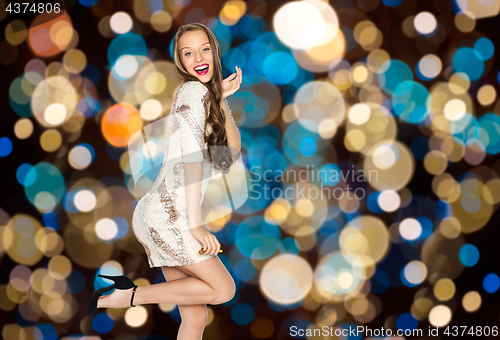 Image of happy young woman posing over party lights