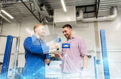 Image of auto mechanic giving key to man at car shop