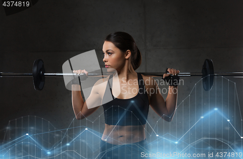 Image of young woman flexing muscles with barbell in gym